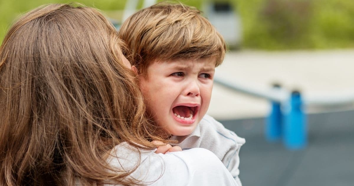 Dentist reassuring child in dental chair.